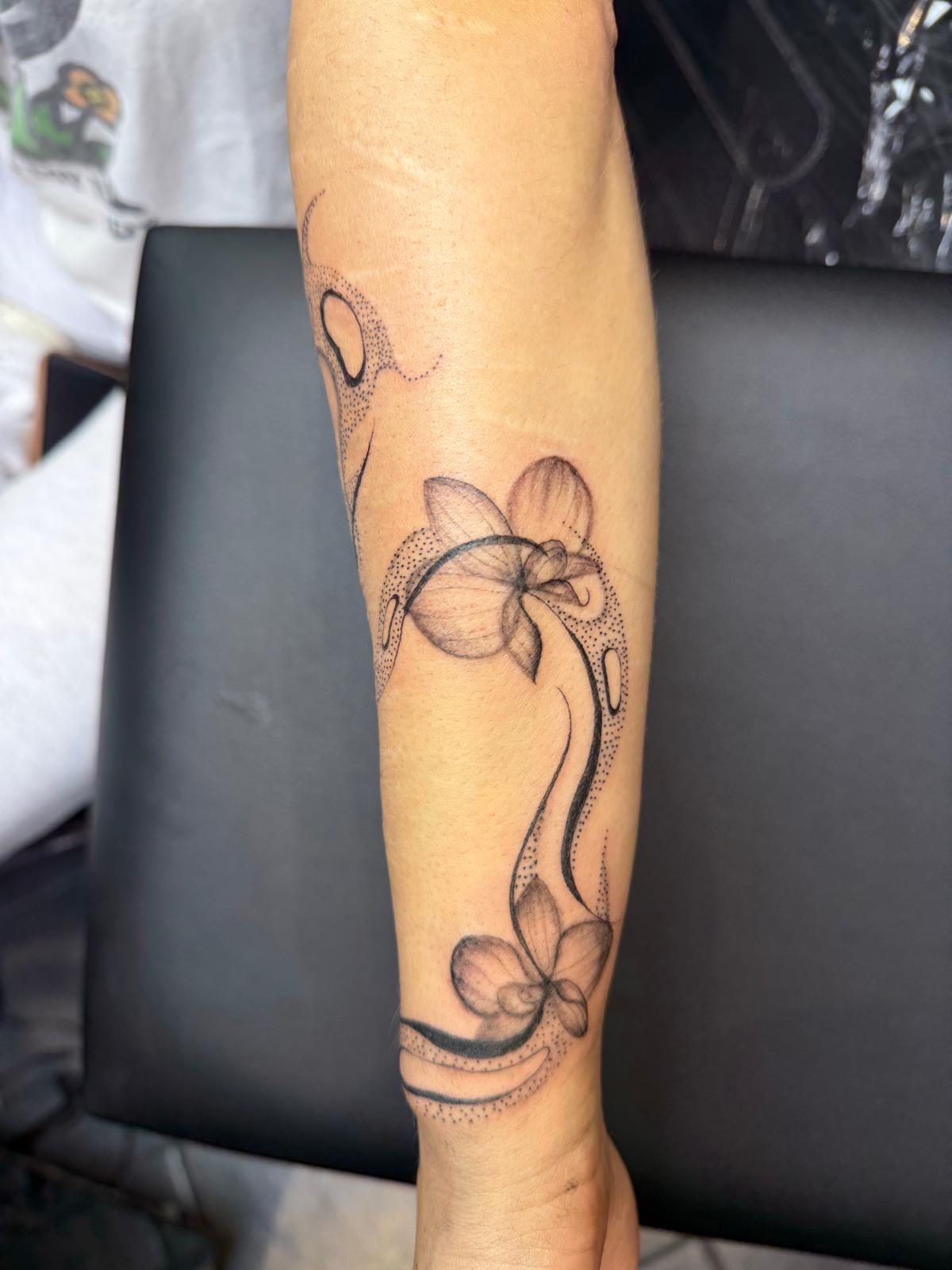 Fine line botanical orchid and dotwork forearm tattoo by Jodi Tattoos in Galway